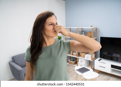 Woman Covering Her Nose From Bad Smell Inside The House