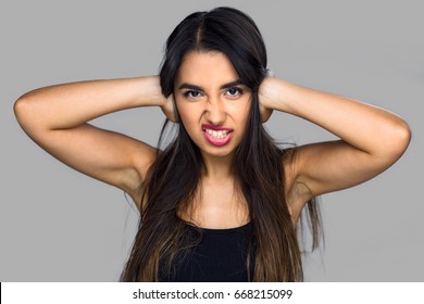 Woman covers her ears blocking loud noises music annoyed and stubborn refusing to listen