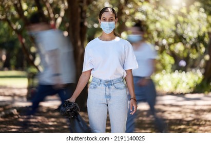 Woman In Covid Face Mask Cleaning The Park For Clean, Hygiene And Safe Green Environment. Responsible Activist, Volunteer Or Community Service Worker With Rubbish, Trash And Garbage In A Plastic Bag