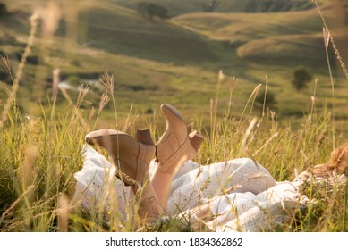 Woman In Cowboy Boots Resting In The Mountains