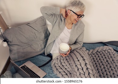 Woman In Cozy Home Clothes Relaxing At Home ,using Computer, Drinking Coffee, Mature Business Woman Working From Home