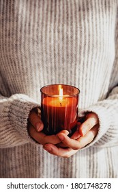 Woman In Cozy Sweater Holding Burning Candle Close-up. Cozy Autumn Or Winter, Hygge Lifestyle