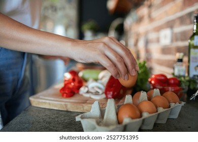 Woman cracking an egg for healthy breakfast preparation in kitchen - Powered by Shutterstock