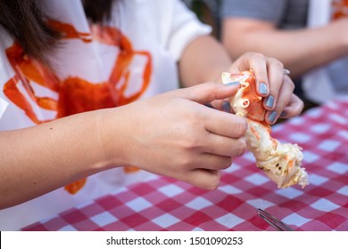 Woman Cracking Open A Boiled Crab Leg, In A Seafood Cookout Concept, With Space For Text On The Left