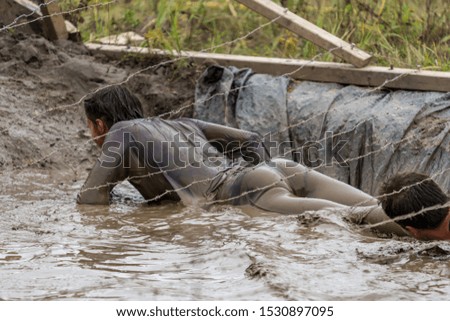 Woman crawling under barbed wire at an obstacle course race