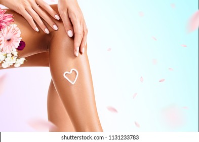 Woman With Cream On Her Leg And Flowers Bouquet. Over Background With Swirl Petals