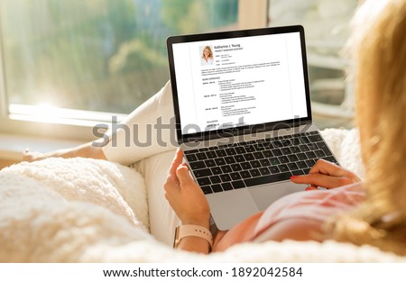 Woman creating her CV on computer at home