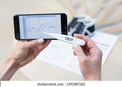 Woman creating a temperature chart to identify the day she ovulates.