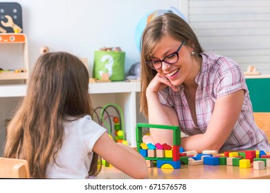 Woman with creative kid having fun time playing colorful with toy blocks - Shutterstock ID 671576578