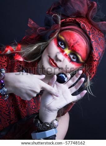 Woman with creative make-up  with strass in her hands