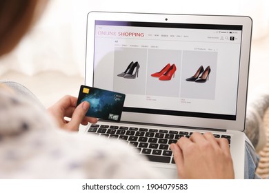 Woman with credit card using laptop for online shopping indoors, closeup