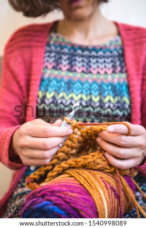 Woman crochets. Handwork. Crochet hook. Female hands closeup. Female hands hold the hook. Vintage carpet. Knitted plaid. Handmade. Home hobby.