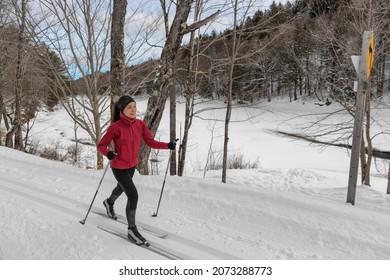 Woman Cross Country Skiing Classic Style Nordic Skiing In Forest. Woman In Winter Doing Fun Winter Sport Activity In The Snow On Cross Country Ski In Beautiful Nature Landscape