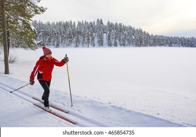 Woman cross country skiing in Lapland Finland near frozen lake
