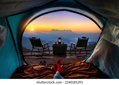 Woman cross leg on blanket in camping tent with sleeping bags on mountain hill. view from inside with Doi luang chiang dao mountains. - Powered by Shutterstock