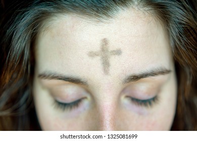 woman with cross on forehead in observance of Ash Wednesday religious concept