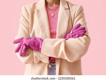 Woman with crossed hands in rubber gloves and jewelry on color background, closeup