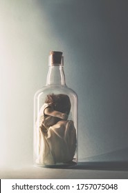 Woman Crouching Inside A Glass Bottle