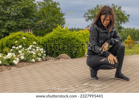 A woman crouching next to the sign 