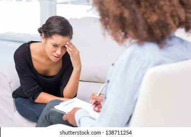 Woman Crying On Sofa During Therapy Session While Therapist Is Taking Notes