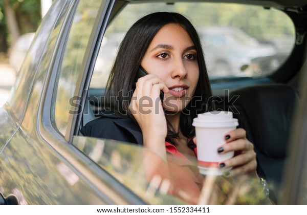 Woman with cup of coffee in\
car
