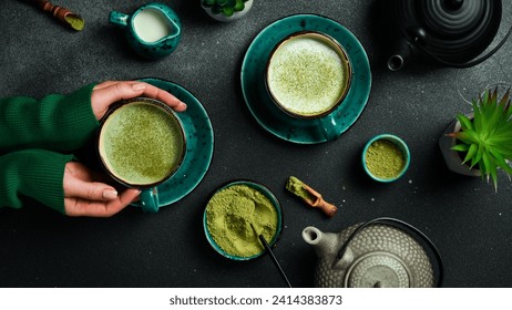 Woman with cup of delicious matcha latte on dark gray background, closeup. Top view. - Powered by Shutterstock