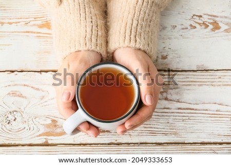 Woman with cup of hot tea at table
