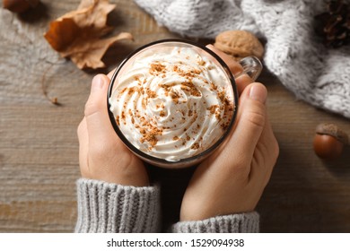 Woman With Cup Of Pumpkin Spice Latte At Wooden Table, Above View