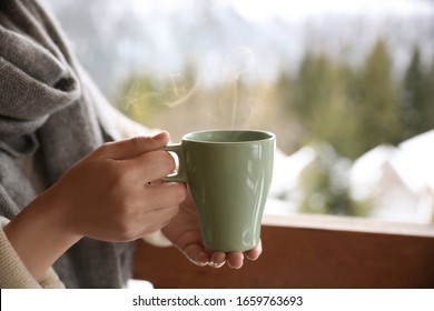 Woman with cup of tasty coffee outdoors on winter morning, closeup - Powered by Shutterstock