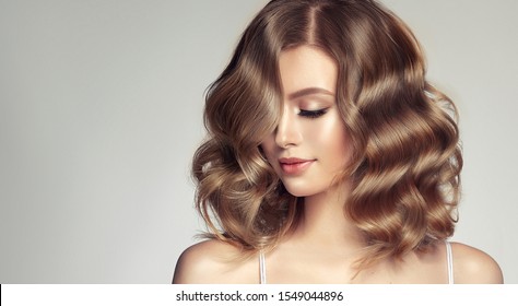 Woman with curly beautiful hair  on gray background. Girl with beauty a pleasant smile. Short wavy  hairstyle - Shutterstock ID 1549044896
