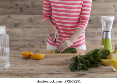 Woman cut vegetables on wooden table prepared to make vegetable juice.