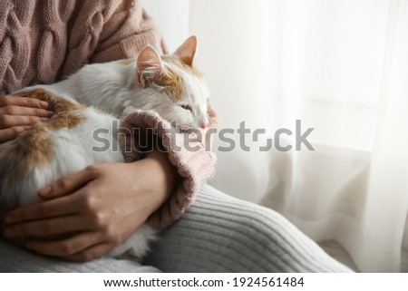 Woman with cute fluffy cat indoors, closeup