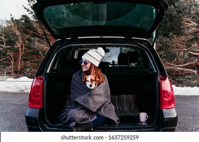 woman and cute jack russell dog enjoying outdoors at the mountain into the car. Travel concept. winter season