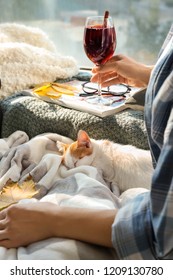 Woman With Cute Little Kitten And Glass Of Delicious Mulled Wine Resting At Home