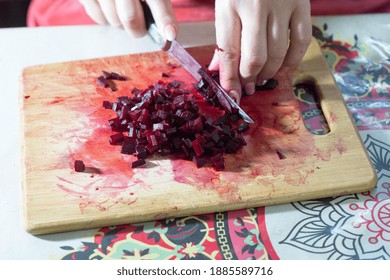 Woman Cuts Beets On A Cutting Board.