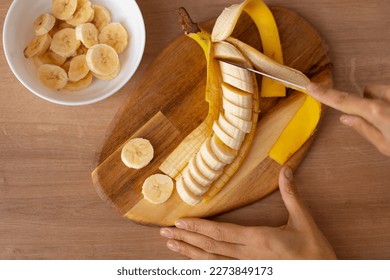 mujer cortando rebanadas de plátano. banana rebanada. rodajas de plátano. preparar ensalada de fruta. alimentos saludables.