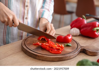 Woman Cutting Bell Pepper In Kitchen, Closeup