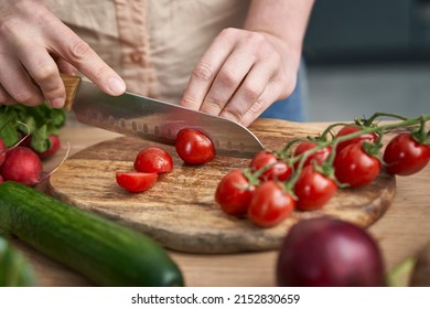 Woman cutting cherry tomatoes on wooden board - Powered by Shutterstock