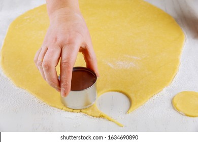 Woman Cutting Dough For Making Sugar Cookies On White Table.