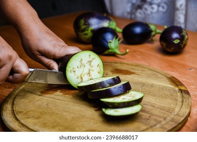 Woman cutting eggplant on a cutting board - Powered by Shutterstock