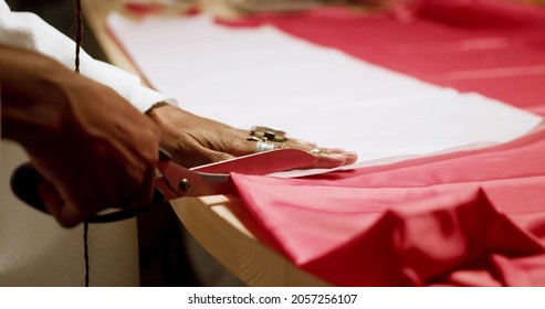 A woman is cutting fabric with a scissors - Powered by Shutterstock