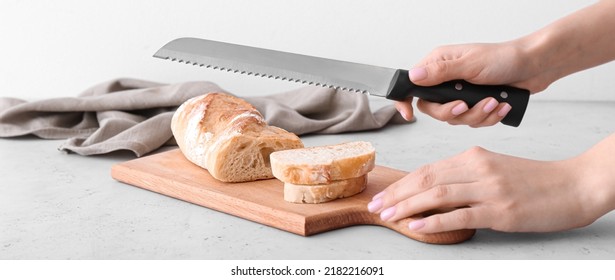 Woman Cutting Fresh Bread On Wooden Board