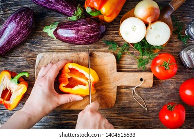 Woman cutting fresh pepper. Vegan dinner cooking. Summer seasonal vegetarian, top view