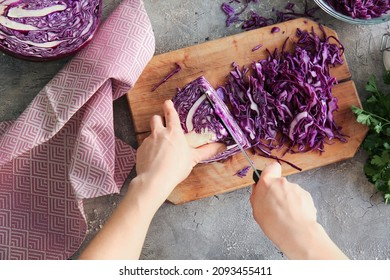 Woman cutting fresh purple cabbage on table - Powered by Shutterstock