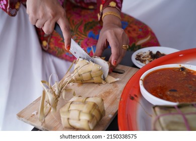 A woman is cutting Javanese rice cake with a knife. Selected Focus Ketupat Lebaran. Traditional Celebratory Menu during Eid al-Fitr and Eid al-Adha in Malaysia, Indonesia, Singapore, and Brunei.