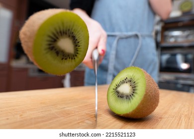 Woman Cutting A Kiwifruit In Half