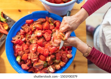 Woman Cutting Large Amount Of Tomatoes For Prepare Tomato Sauce. Preparation Of Tomatoes For Cooking . 