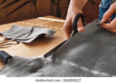Woman cutting out a pattern paper in linen fabric. Seamstress sewing on the sewing machine in small studio. Fashion atelier, tailoring, handmade clothes concept. Slow Fashion Conscious consumption - Shutterstock ID 2062858127