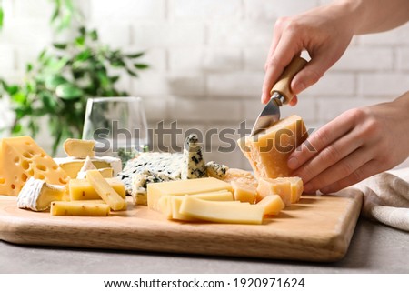 Woman cutting parmesan for cheese plate at table, closeup ストックフォト © 