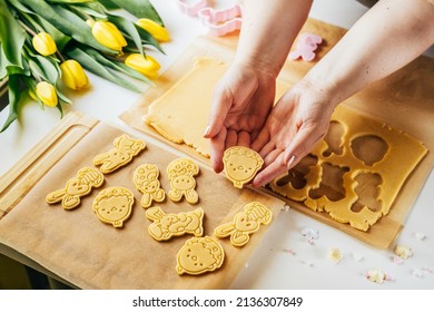 Woman Cutting Pastry Dough Into Easter Egg Shape While Making Sugar Cookies. Holidays Baking. Top View